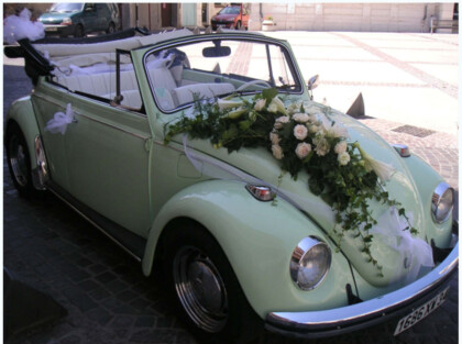<br/>Composition florale pour décorer la voiture des mariés. Votre fleuriste choisit les fleurs et la forme de la composition pour qu'elles s'adaptent bien à la forme de la voiture.